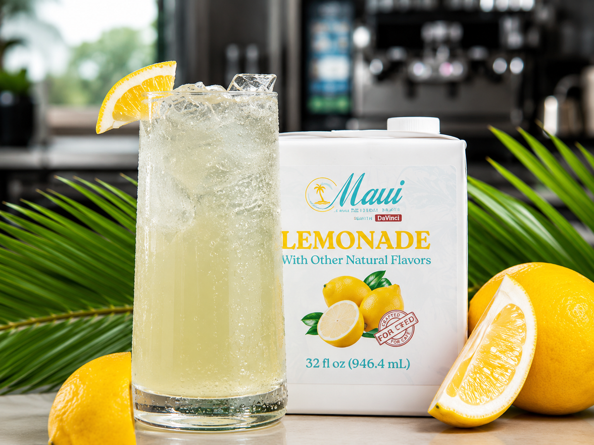 A 32 fl oz white canister of Maui Lemonade with other natural flavors stands next to a tall glass of pale yellow lemonade with ice, garnished with a lemon wedge, surrounded by lemons and green palm leaves.